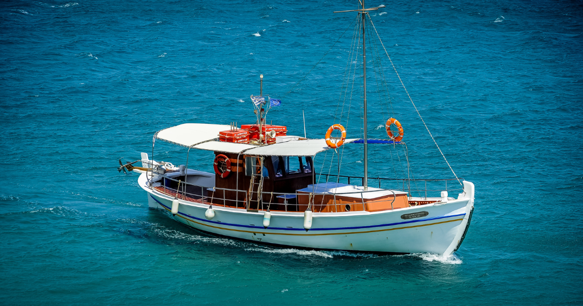 Boat floating peacefully on Lake Naivasha surrounded by calm blue waters and lush greenery.